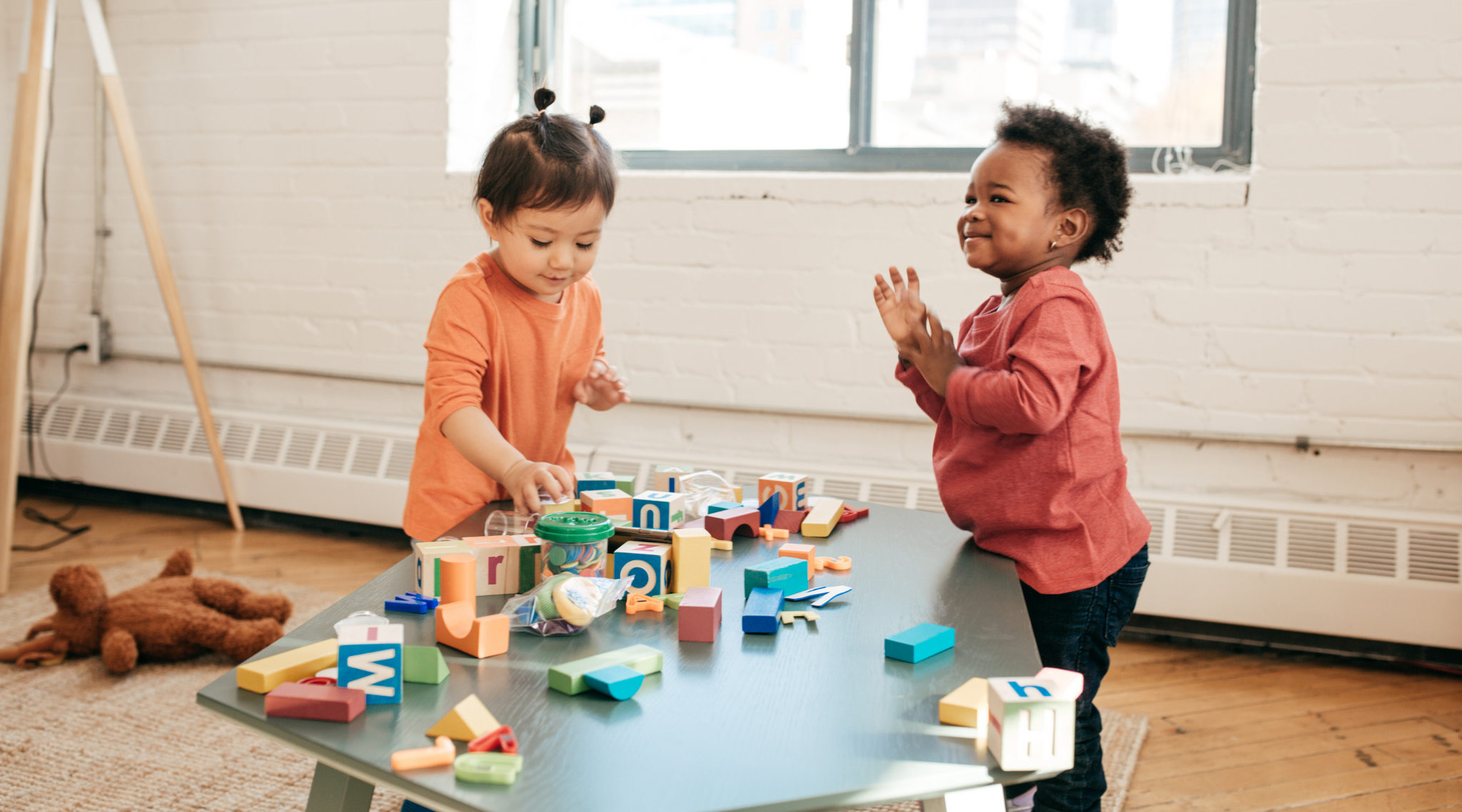 Photo of two toddlers playing with blocks